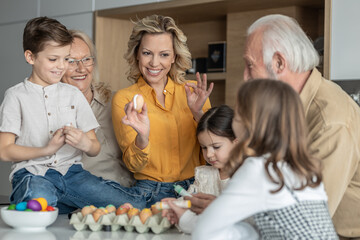 Mom showing her kids how to decorate Easter eggs