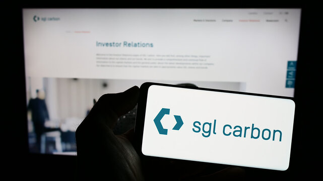 Stuttgart, Germany - 03-13-2023: Person holding cellphone with logo of German chemicals company SGL Carbon SE on screen in front of business webpage. Focus on phone display.