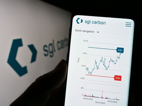 Stuttgart, Germany - 03-13-2023: Person holding smartphone with webpage of German chemicals company SGL Carbon SE on screen in front of logo. Focus on center of phone display.