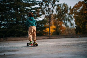 Niño con patinete en el parque 