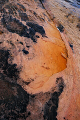 Orange and black rock structures in river bed on the plateau of Auyan Tepui in Venezuela