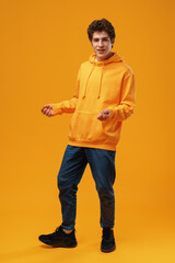 Young cheerful man dancing having fun over yellow background