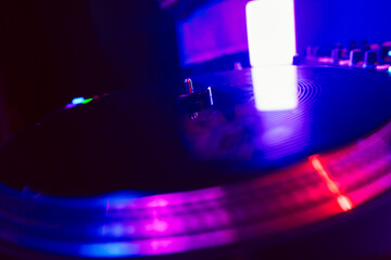 Close up of DJ mixing console in party light