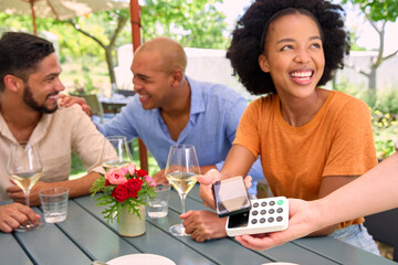 Woman Paying Bill At Outdoor Bar Or Restaurant Using Contactless App On Mobile Phone