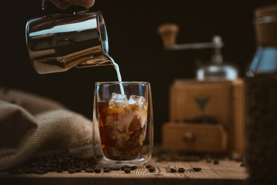 pouring milk in a cold brew coffee