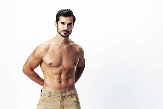Man athlete model with a naked torso and six pack abs sporty inflated figure and tan on a white isolated background, fashionable clothing style, copy space, space for text