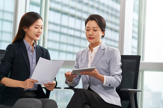 young asian businesswomen discussing business in office using digital tablet