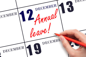 Hand writing the text ANNUAL LEAVE and drawing the sun on the calendar date December 12