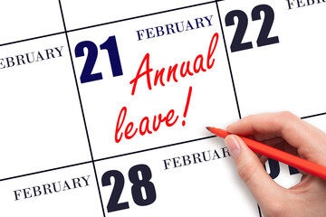 Hand writing the text ANNUAL LEAVE and drawing the sun on the calendar date February 21