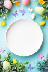 Naklejka na ściany i meble Easter table setting, Easter food background. White plate with eggs, spring flowers, green leaves and butterfly. Flat lay.