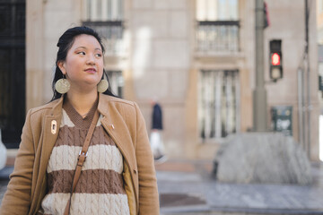 Close-up of young Asian woman crossing the street with red traffic light.