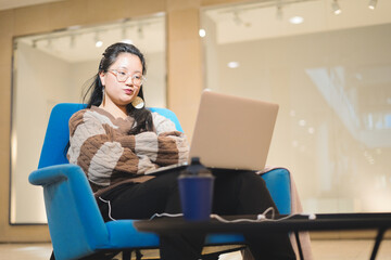Young Asian girl working angry in a rest area of a shopping mall. Concept of teleworking.