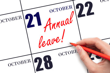 Hand writing the text ANNUAL LEAVE and drawing the sun on the calendar date October 21