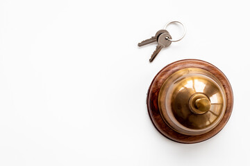 Golden hotel service bell with key on reception desk