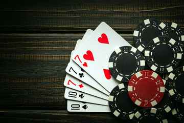 Playing poker with a winning combination of full house or full boat. Cards with chips on a black...