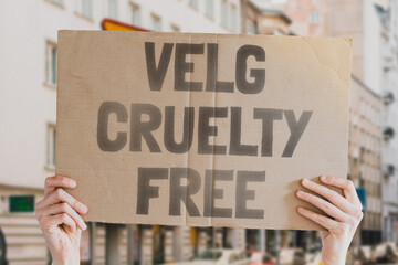 The phrase " Choose cruelty free " is on a banner in men's hands. Animal rights protest. Protection. City. Urban. Rally. Freedom. Stop animal testing. Equality. Justice. Care. Life. Humanity