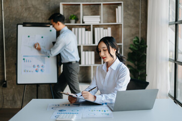 Young beautiful woman using laptop and tablet while sitting at her working place. Concentrated at work. in office..
