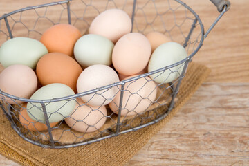 Fototapeta na wymiar chicken eggs in a basket on a wooden background, farm food. Selective focus.