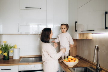 Healthy food at home. Happy family in the kitchen. Mother and child daughter are preparing the vegetables and fruit.