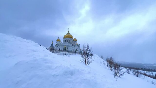 Belogorsky St. Nicholas Orthodox Missionary Monastery. Russia, Perm Krai, Belaya Gora. The temple on the hill in winter. Monastery on the background of snow. 4K