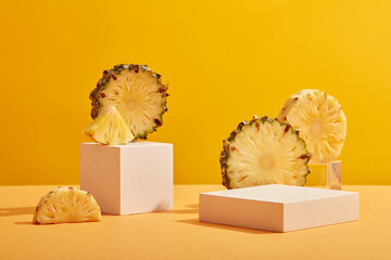 Front view of pineapple fruit cut in half and triangle shape and white empty podium on yellow...
