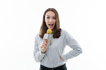 Smiling brunette sings into a microphone on a white background