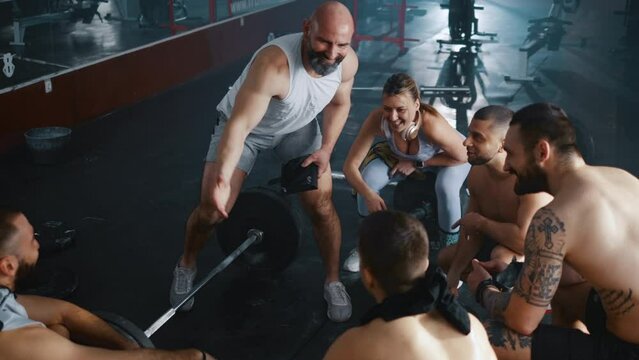 Personal trainer congratulates and motivates a group of athletes to the gym. 