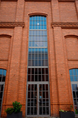 Obraz premium large window in a brick building Modern urban architecture; reconstruction of buildings of the old factory complex; brick walls and large windows of company offices; former workshops