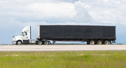 A highway truck hauling freight along a highway. Taken in Alberta, Canada