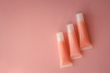 Lip glosses on pink background