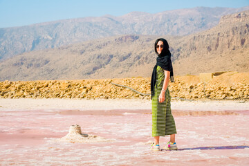 Caucasian woman watch Maharlu pink salt lake panorama in Shiraz, Iran.