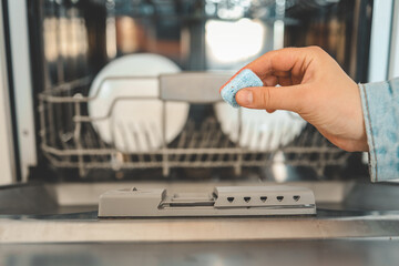 Dishwasher capsule, dishwasher tablets woman puts the capsule in the dishwasher