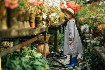 Child planting spring flowers. Little girl gardener plants azalea. Girl holding azalea bush in flower pot. Child taking care of plants. Toddler with flower basket. girl holding pink flowers