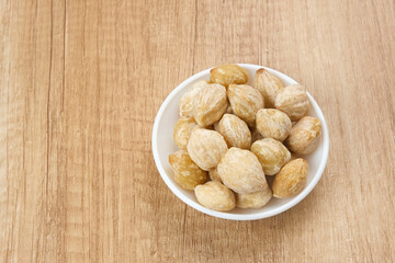 Kemiri or Candlenut Seeds on wooden background, food ingredient
