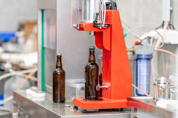 capping beer bottles on a machine in a brewery