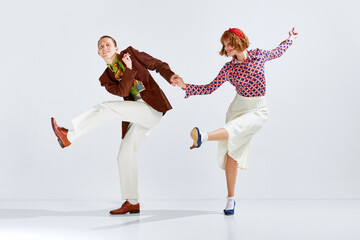 Synchronization of movements. Yung positive man and woman in stylish clothes dancing retro dance...