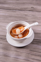 luxury traditional ice cold longan peach gum sea coconut sweet soup in white bowl on wood background asian dessert fresh fruit halal menu