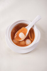 luxury traditional ice cold longan peach gum sea coconut sweet soup in white bowl on wood background asian dessert fresh fruit halal menu