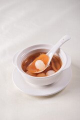 luxury traditional ice cold longan peach gum sea coconut sweet soup in white bowl on wood background asian dessert fresh fruit halal menu