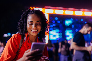 Smiling girl messaging at concert