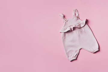 Pink baby girl romper on pastel backgroundd. Set of baby clothes and accessories for spring or summer. Fashion childs outfit. Flat lay, top view. Copy space