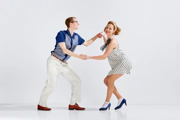 Cercles muraux École de danse Young man and woman in stylish clothes dancing retro dance against grey studio background. Social dance club. Concept of art, retro style, hobby, party, fun, movements, 60s, 70s culture