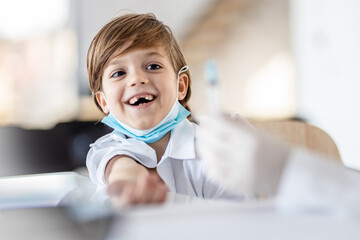 Little boy looking at a vaccine needle
