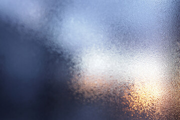 Misted window with condensation against the backdrop of sunset