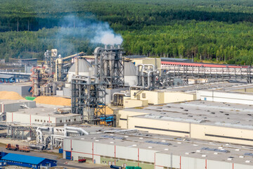 aerial panoramic view of city with a huge factory with smoking chimneys in the background