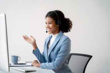 Serious call center operator in wireless headset talking to customer, woman in headphones with microphone consulting customer on phone in customer support service, looking at computer screen.