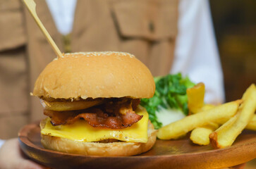 Delicious burgers, potato chips and salads on wooden trays in the restaurant.