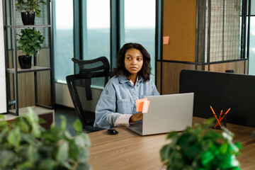 Portrait of a young businesswoman working on a laptop in an office