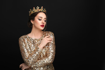 Beautiful young woman wearing luxurious crown on black background, space for text © New Africa