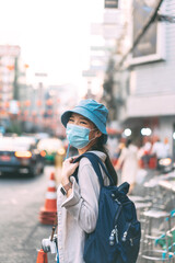 Vertical portraitsian woman backpack traveler wear face mask at Bangkok city